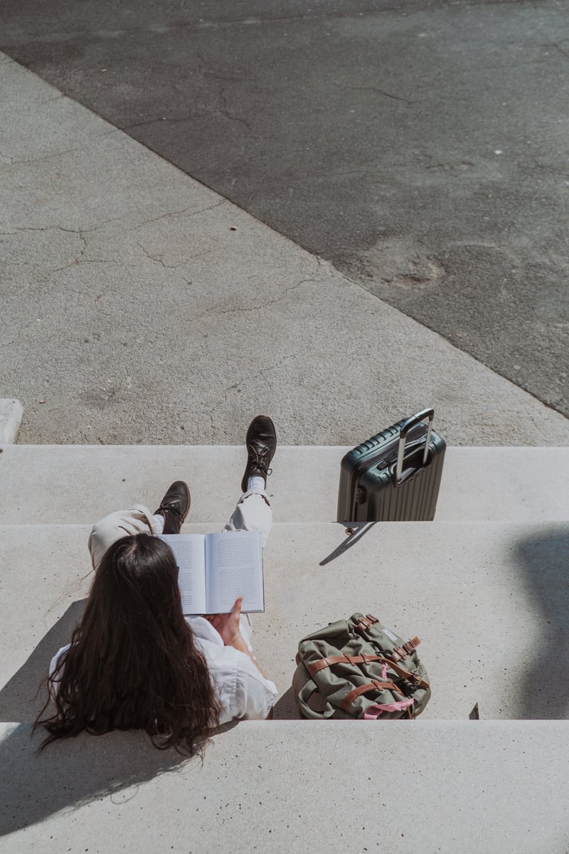 a person reading a book on the steps of a building